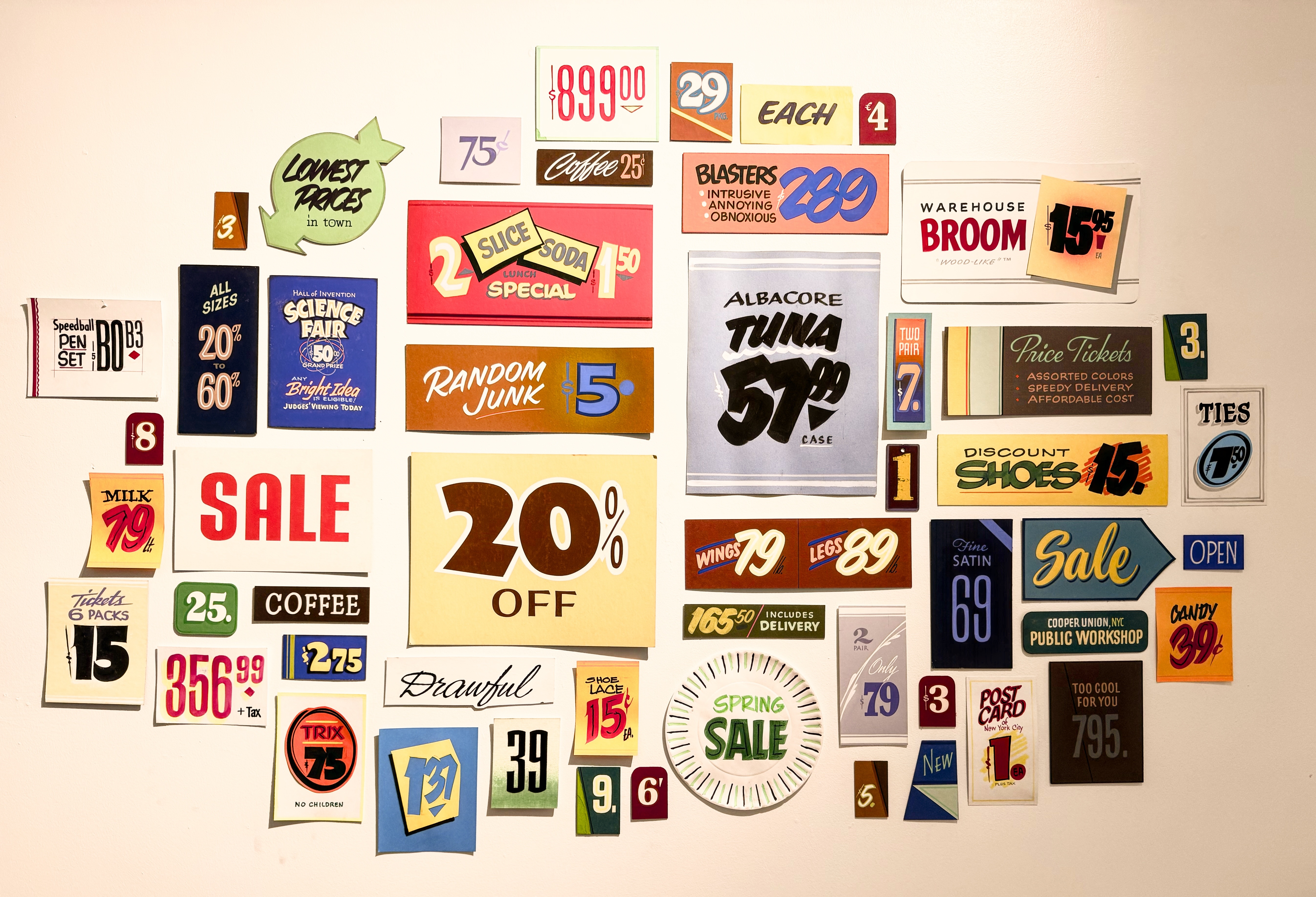 A white wall of little brush lettered signs arranged in a collage